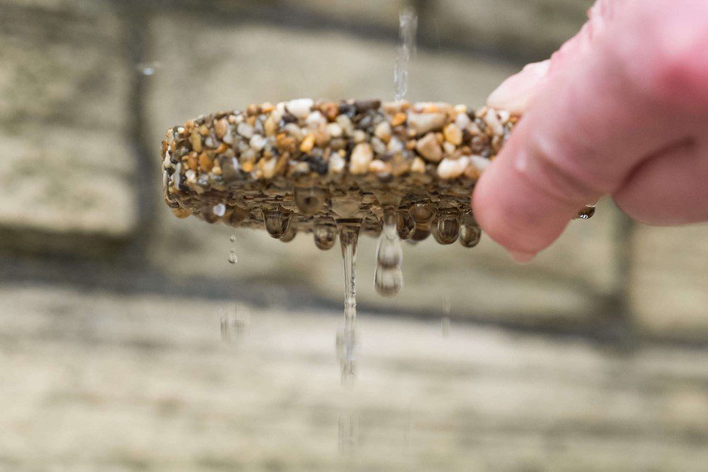 A sample of permeable resin driveway showing water draining through